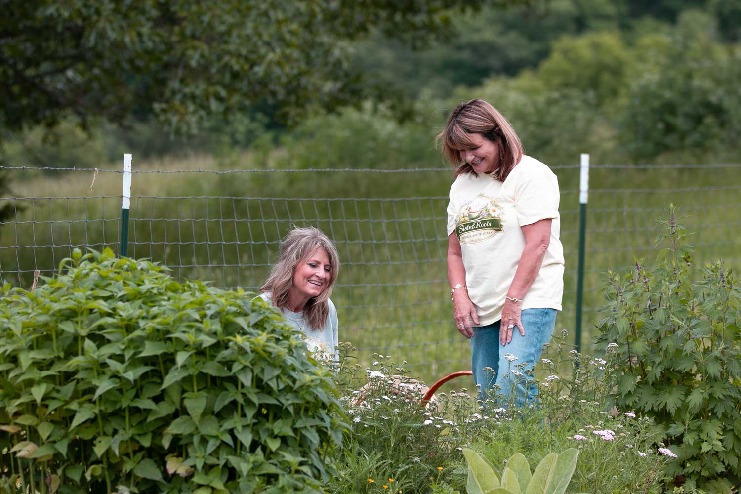 Sister Roots sisters tending their herbal apothecary garden together